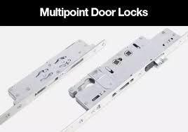 A close-up, studio shot of two multipoint door locks is shown against a white background. The locks are made of silver-toned metal and appear to be mechanical components with various levers, gears, and screw holes. The image is overlaid with the text "Multipoint Door Locks" in white lettering against a black bar at the top.